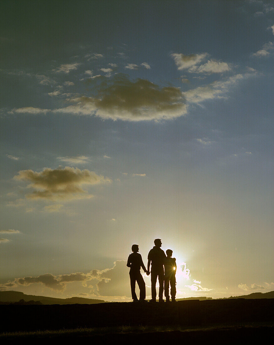 Family with son walking in the sunset, near Hameln, Weserbergland, Lower Saxony, Germany