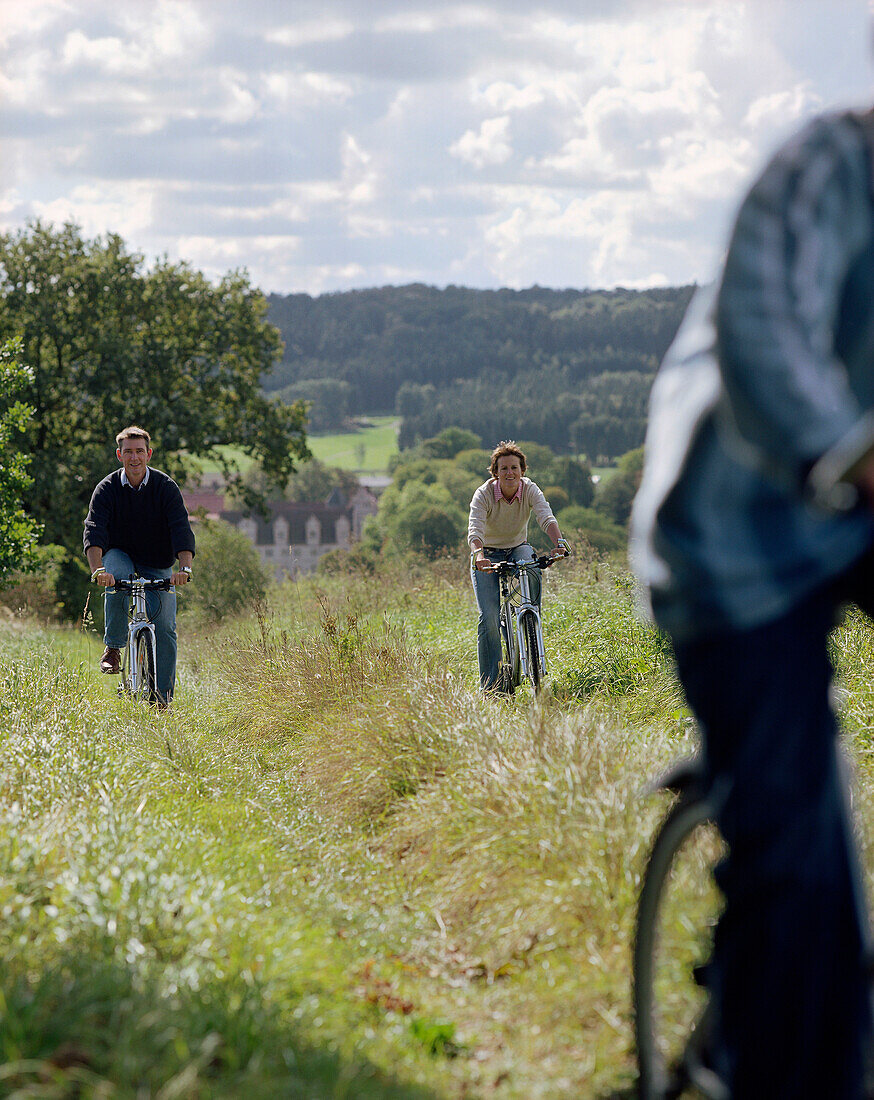 Junge, sportliche Familie mit Sohn, Fahrradtour auf einem Wiesenweg, nahe des Schloßhotels Münchhausen, bei Hameln, Weserbergland, Niedersachsen, Deutschland