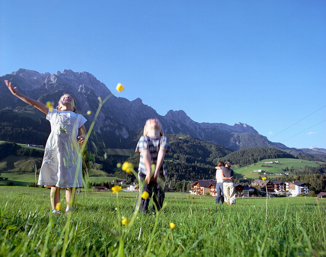 Mädchen und Junge spielen auf einer Wiese, Leogang, Salzburg, Österreich