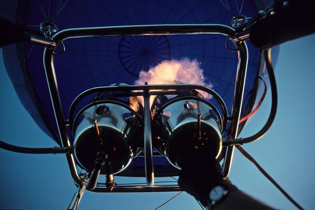 Pilot zündet während der Startphase den Brenner eines Heißluftballons, Flamme, Ballonhülle