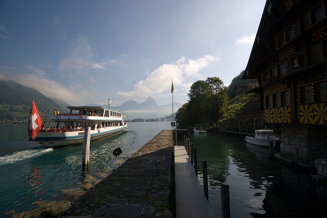 MS Brunnen on Lake Lucerne passing the former shelter harbour Treib with an old tavern, Treib, Canton of Uri, Switzerland