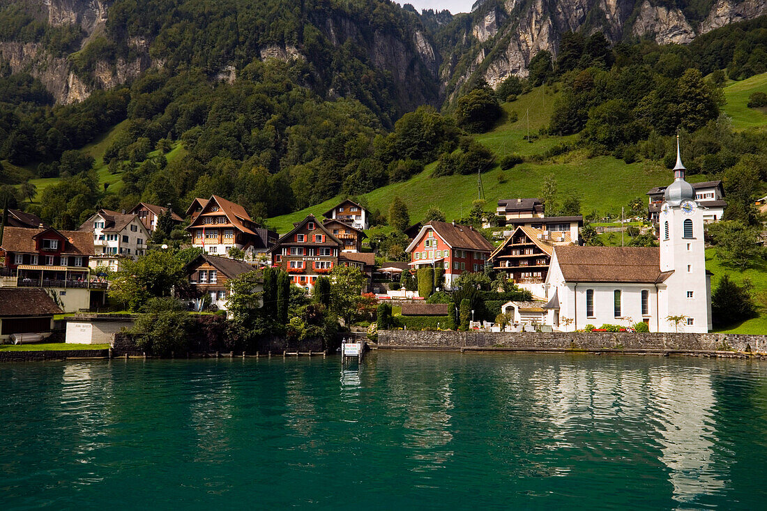 Blick über den Urnersee, ein Teil des Vierwaldstättersees, bei Bauen, kleinstes Dorf in Uri, und Pfarrkirche St. Idda, Kanton Uri, Schweiz