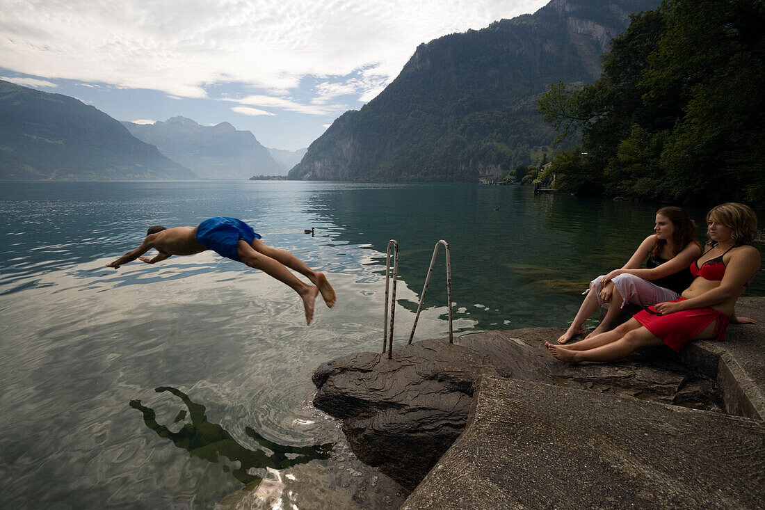 Boy jumping into water of Lake Urnersee, part of Lake Lucerne, Bauen, Canton of Uri, Switzerland