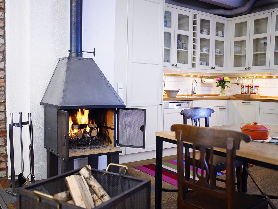 Open plan design kitchen with a wood burning stove next to a dining area