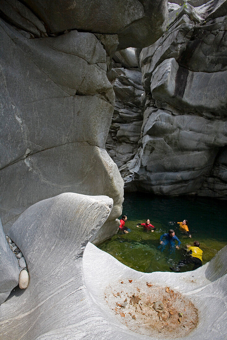 A group of people swims through the Maggia Canyon, Valle Maggia, Ticino, South Switzerland, Switzerland