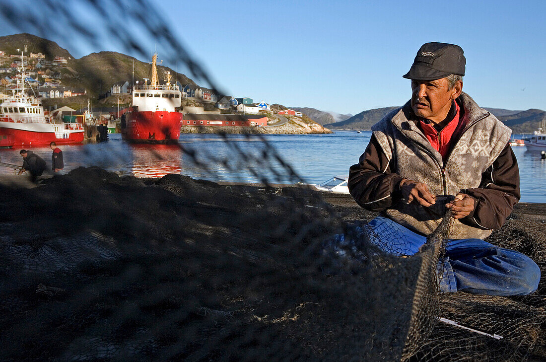 Eskimo, Inuit in Qaqortoq (ehem. Julianehab) repariert ein Fischernetz, Süd Grönland.