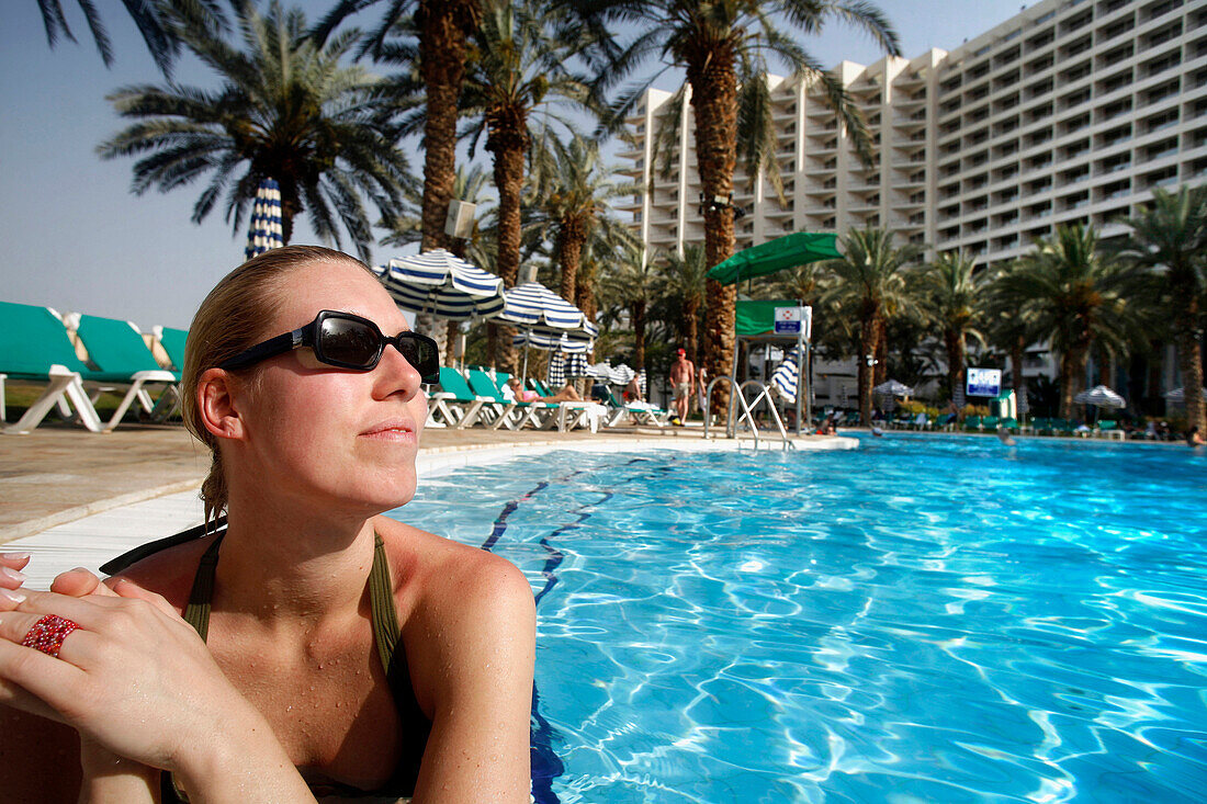 A woman sunbathing in a pool at a hotel resort, Dead Sea, Israel