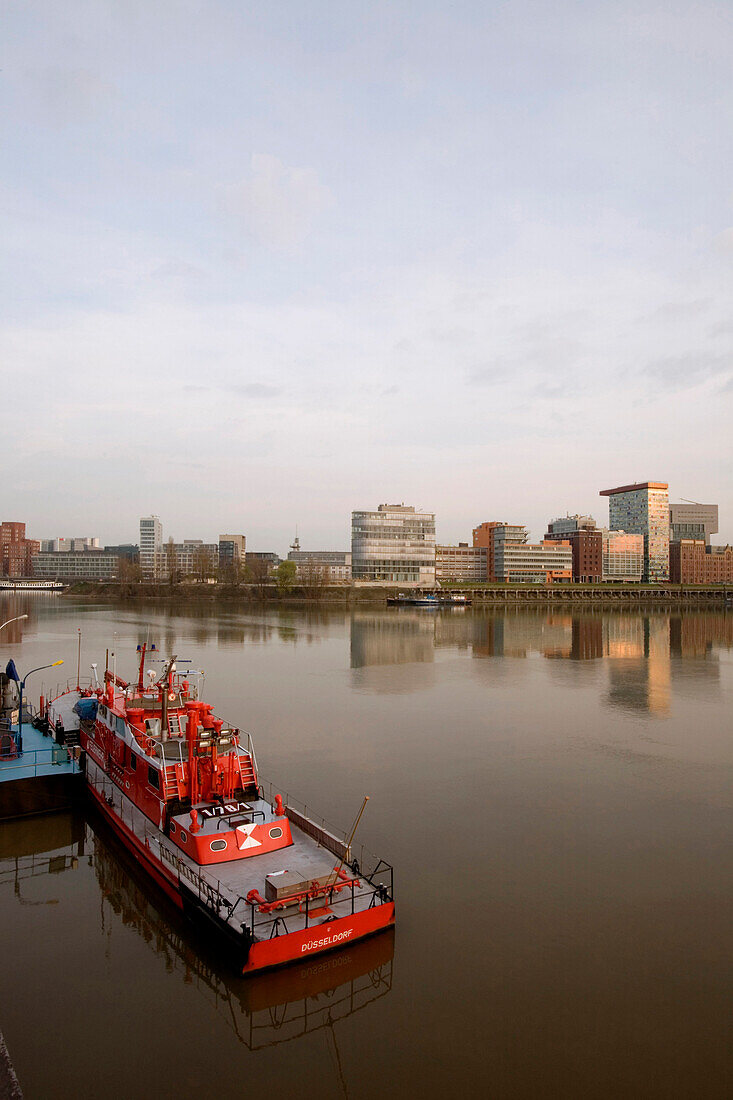 Fire department ship in front of skyline of the district of media, new district of Duesseldorf, North-Rhine-Westphalia, Germany