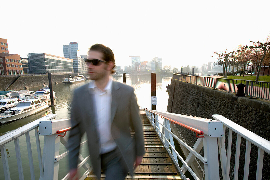 Vorbeigehender Geschäftsmann im Düsseldorfer Medienhafen, Landeshauptstadt von NRW, Nordrhein-Westfalen