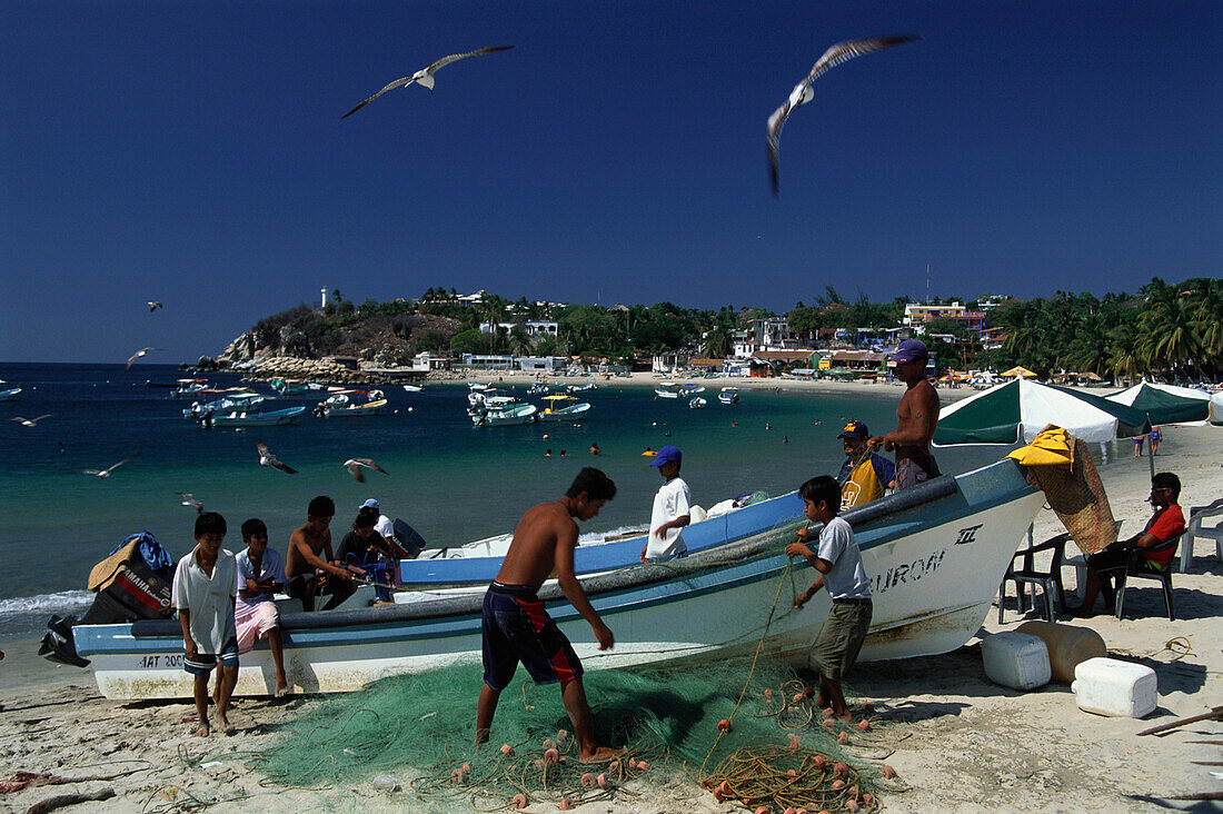 Fischer machen die Netze sauber. Playa Municipial, Puerto Escondido, Oaxaca, Mexiko, Amerika