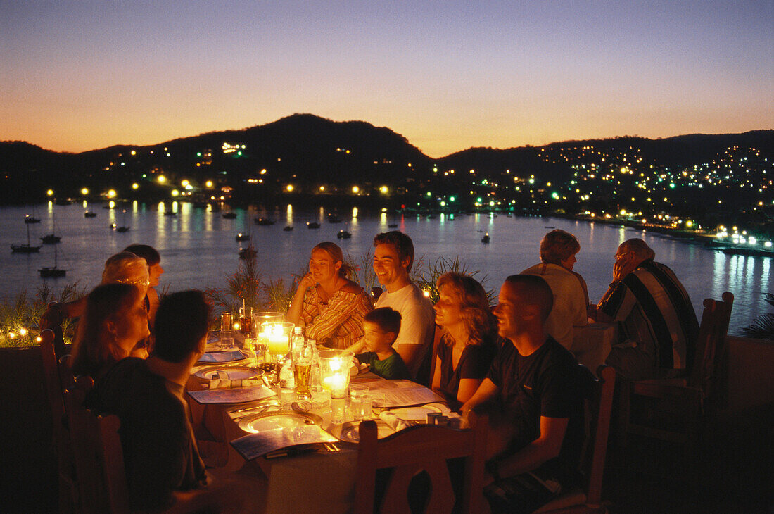People having dinner in Restaurant Kau-Kan at sunset, Zihuatanejo, Guerrero, Mexico, America