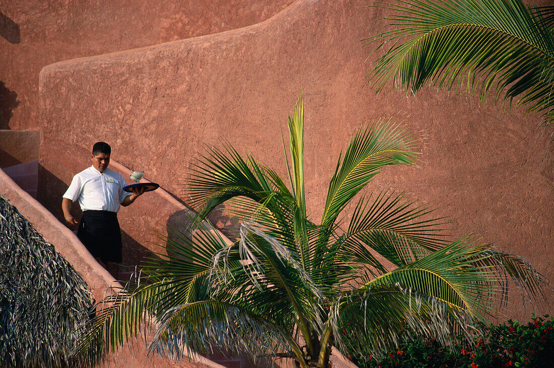 Waiter walking down the stairs, small luxury hotel La Casa que Canta, Zihuatanejo, Mexico