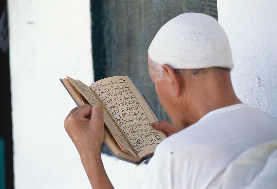 Mann mit Koran, Tozeur, Tunesien, Afrika