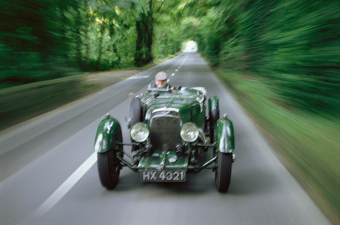 Man driving an oldtimer on a country road, Jersey, Channel Islands, Great Britain