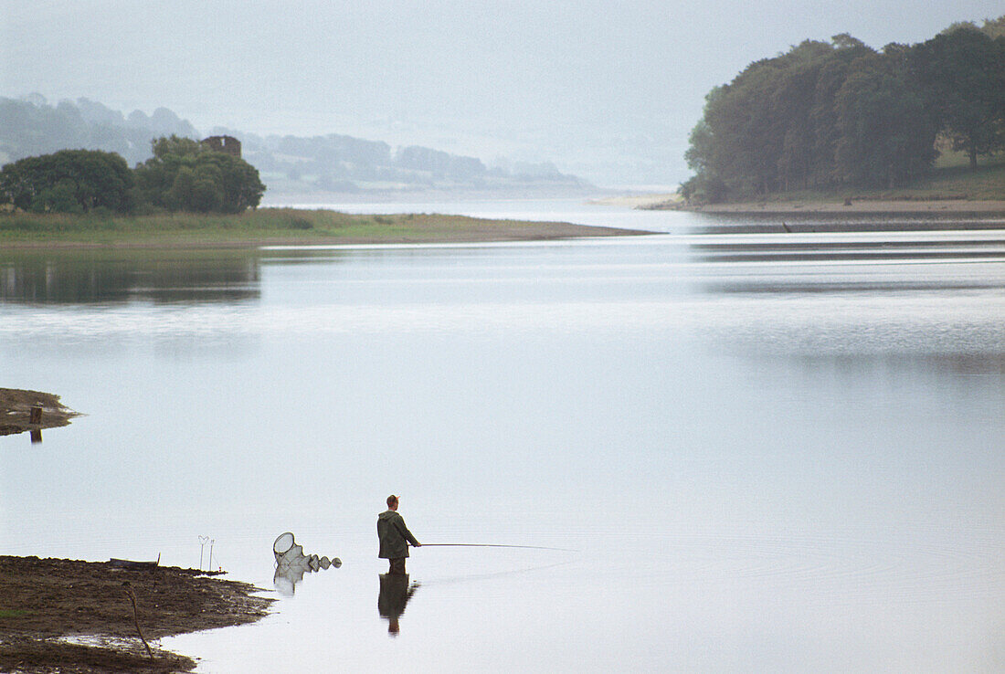 A fisherman fishing in water at Wicklow Mountain, Ireland