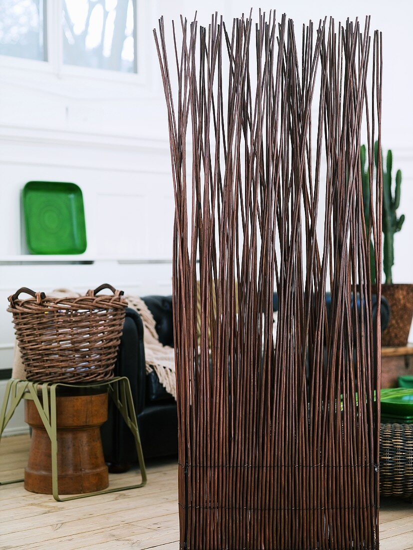 Screen made of willow branches and willow basket on a stool