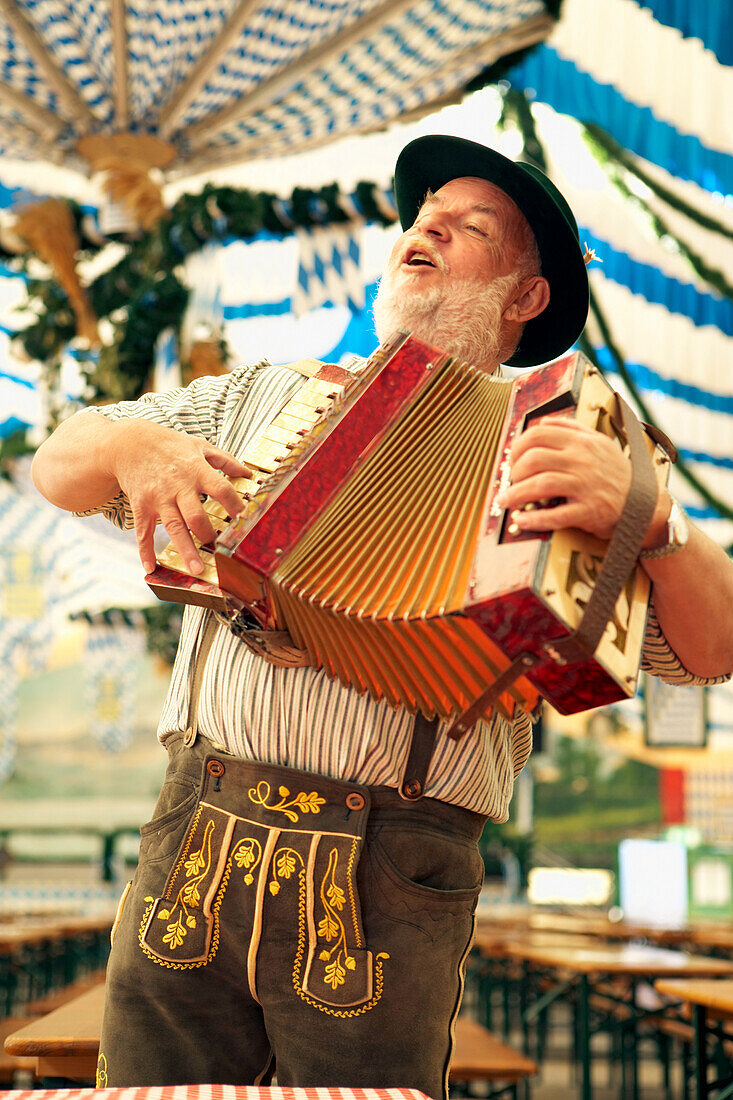 Mann in bayrischer Tracht spielt Akkordeon