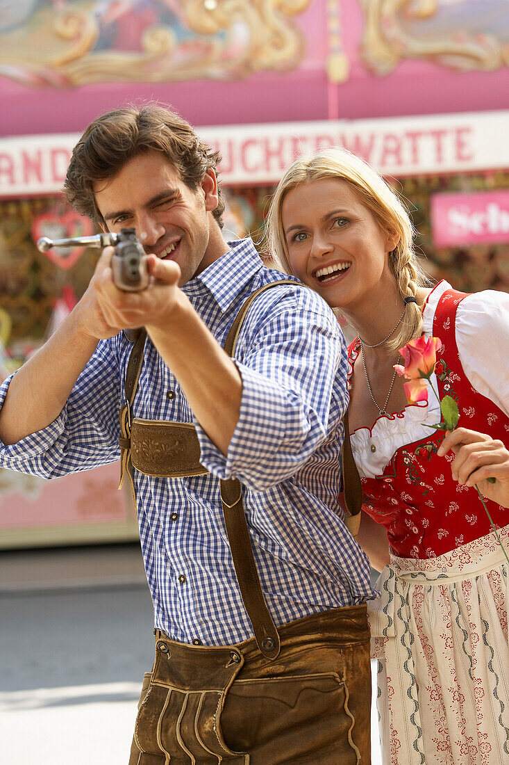 Mann zieht mit Gewehr auf die Kamera, Oktoberfest, München, Bayern, Deutschland