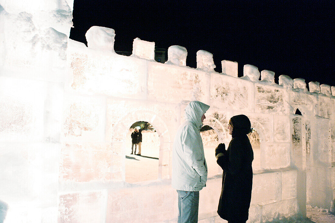 A couple at the ice castle at Lake Louise at night, Alberta, Canada