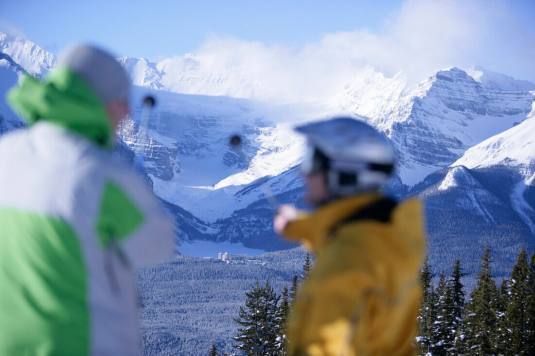 Skiers looking out towards Chateau Lake Louise, Victoria Glacier, Victoria Mountain, Lake Louise, Alberta, Canada