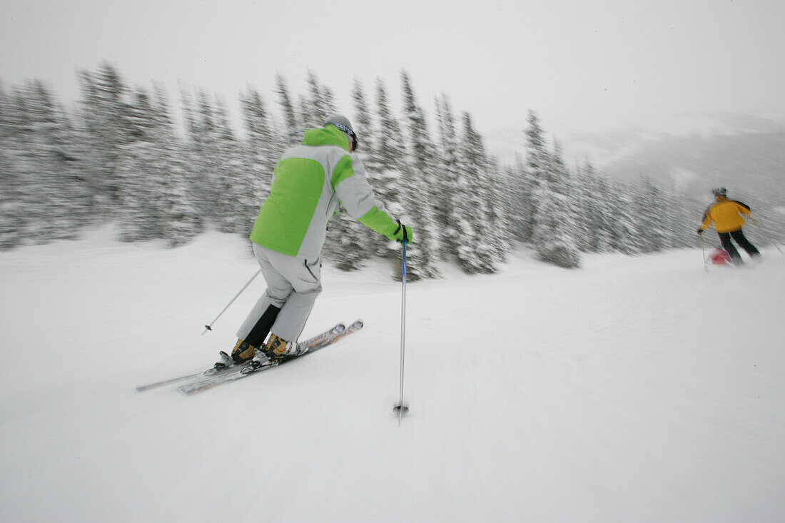 Two skiers on slope, Sunshine Village ski resort, Banff, Alberta, Canada