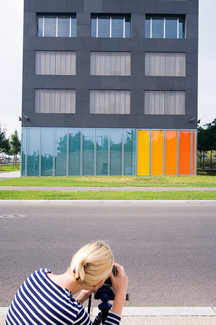 Woman taking picture of colored building, Luxembourg