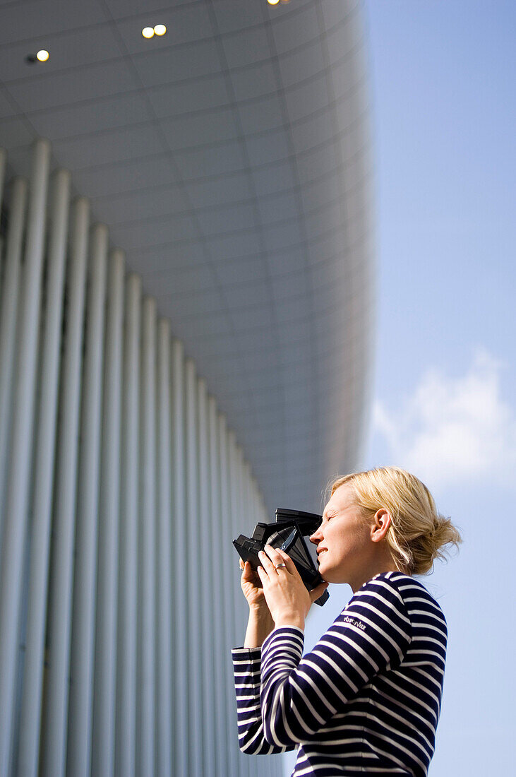 Young woman photographing Philarmonie, Luxembourg, Luxembourg