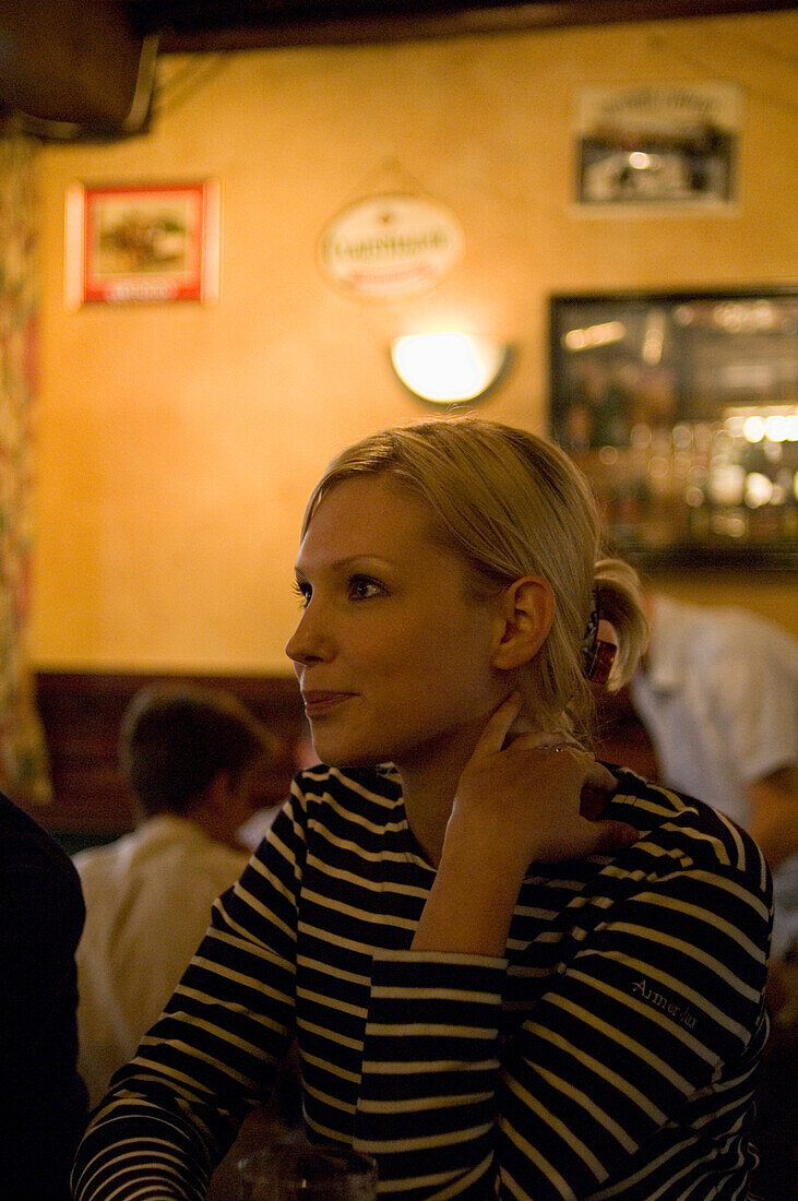 Young woman sitting in a pub, Luxembourg