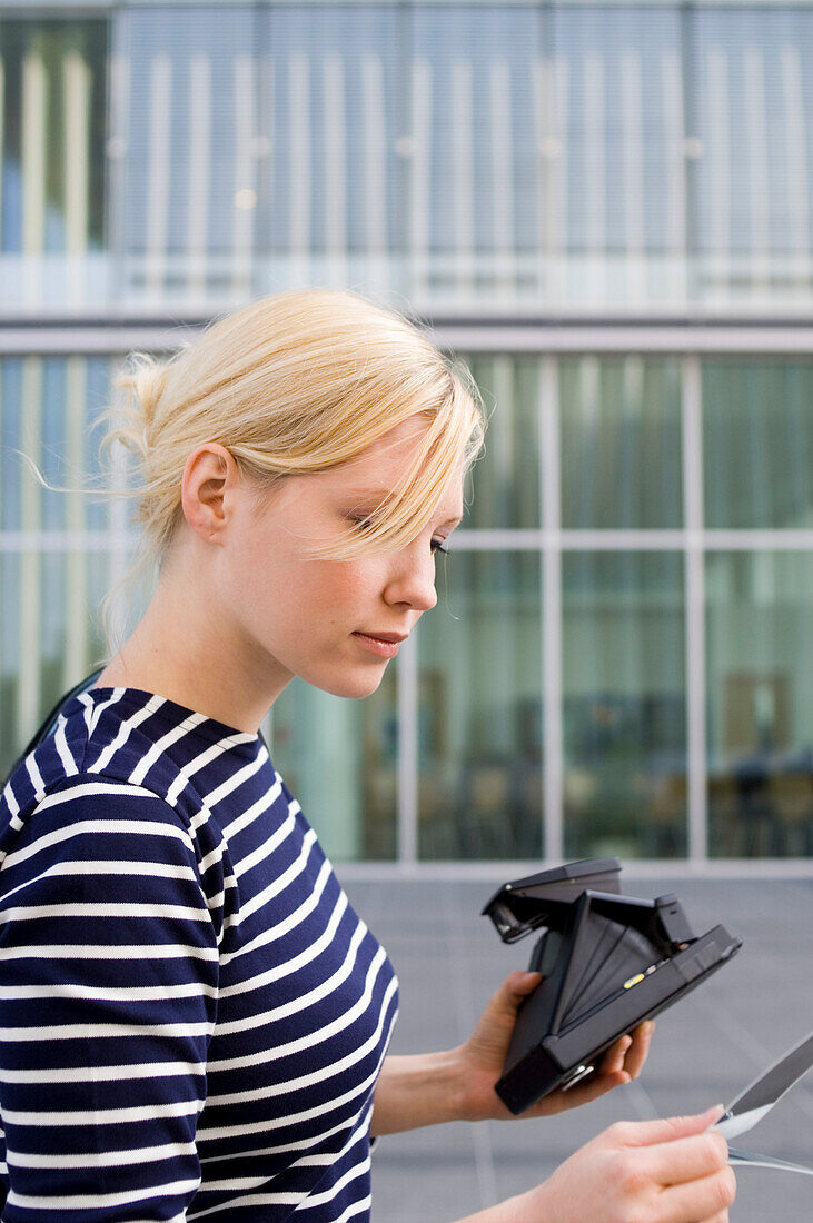 Junge Frau mit Sofortbildkamera und Foto, Luxemburg