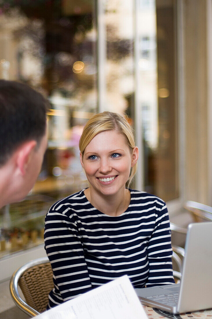 Junge Frau mit Laptop in Café, Luxemburg
