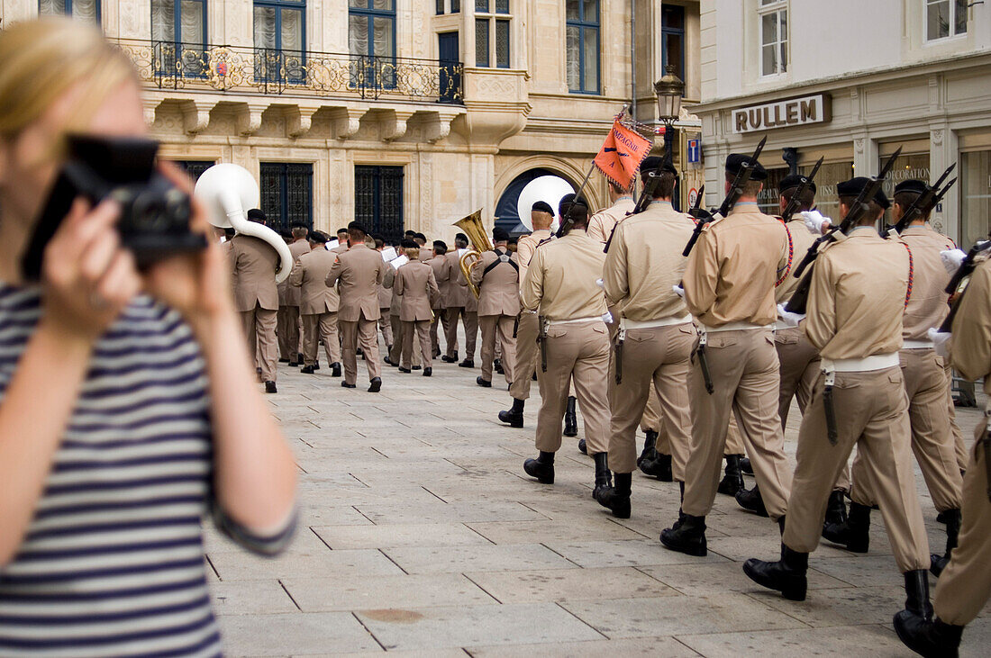 Young woman photographing changing of the guard at Grand Ducal Palace, Luxembourg, Luxembourg