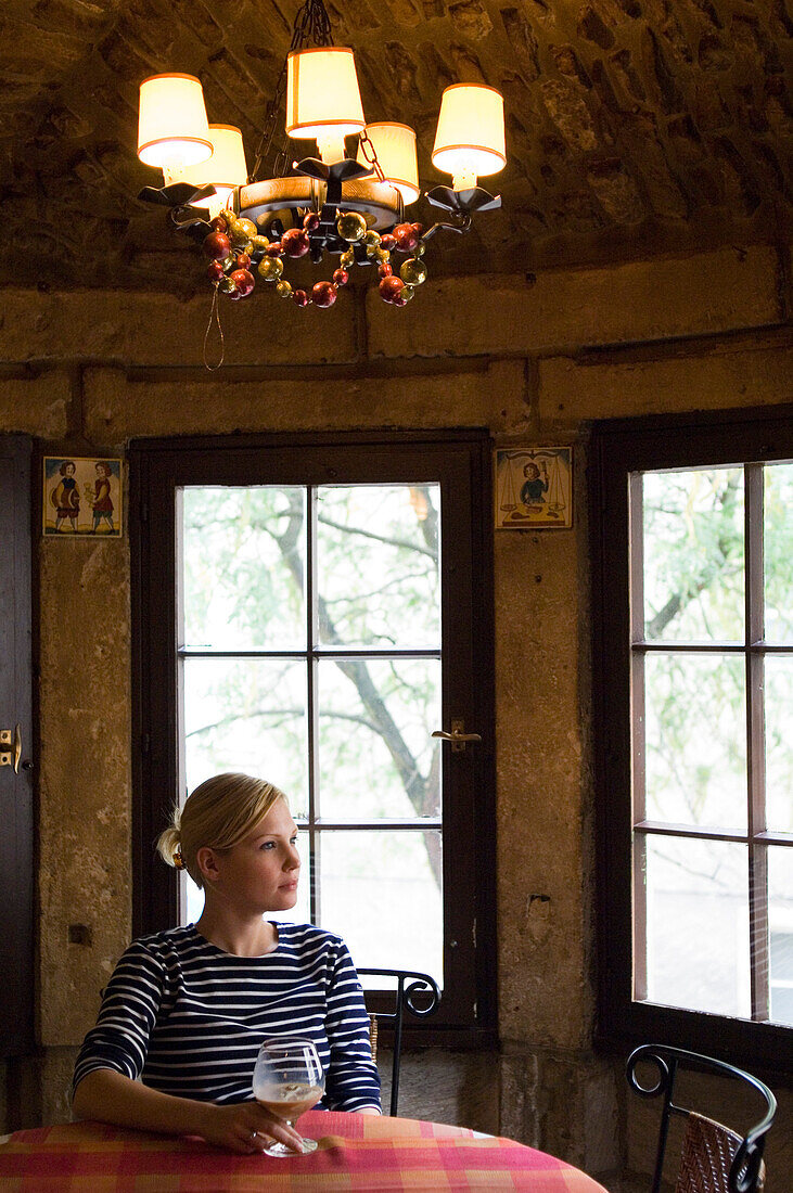 Woman with wine in glass looking out of window, Luxembourg