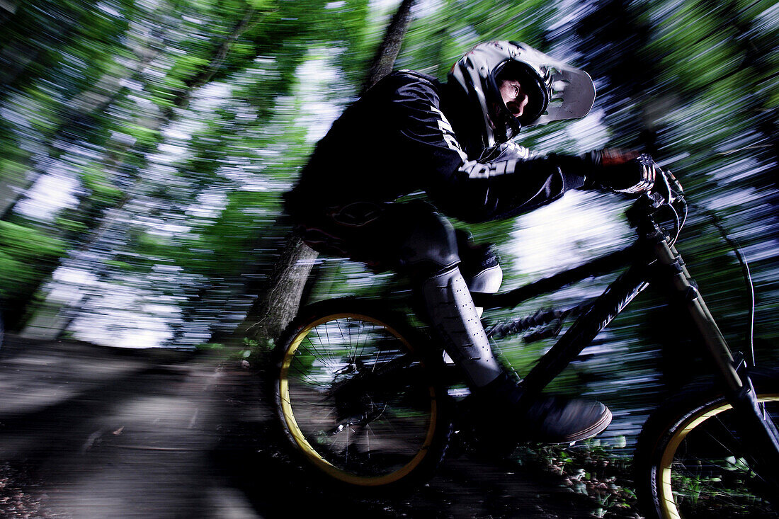 Mountainbiker rideing his bike in the forest, Dillingen, Bavaria, Germany