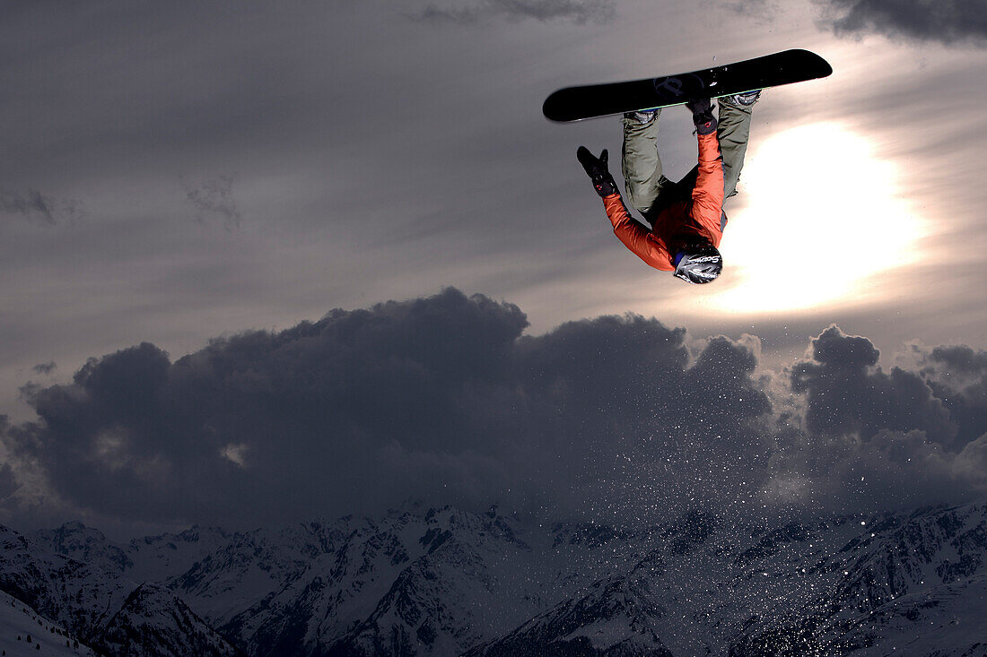 Snowboarder springt im Sonnenuntergang, See, Tirol, Österreich