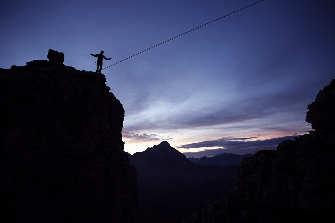 Junger Mann balanciert auf einem Seil zwischen zwei Felsen, Oberstdorf, Bayern, Deutschland