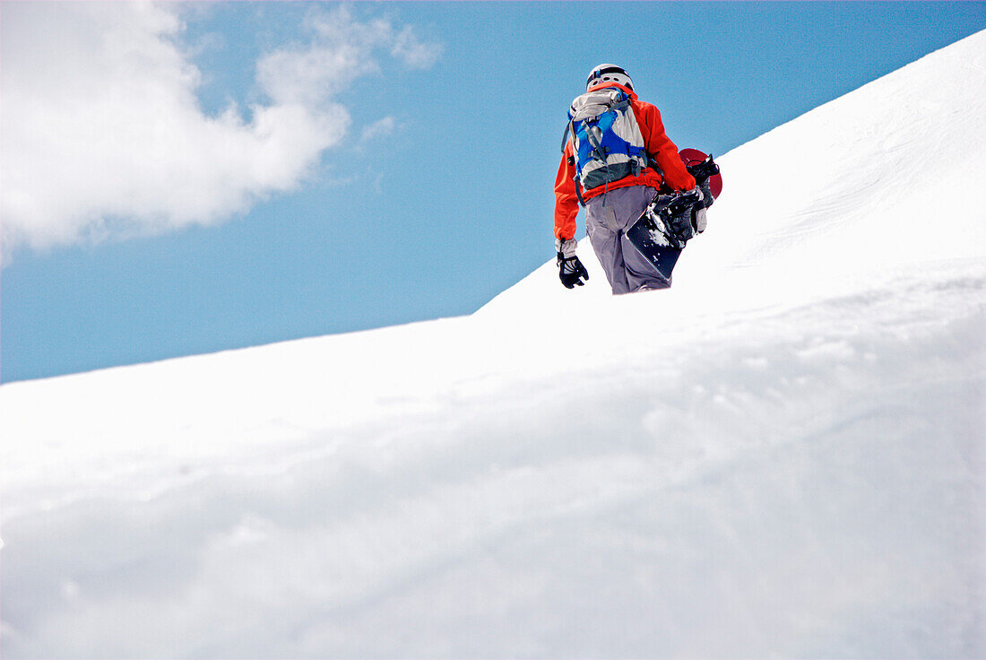 Snowboarder läuft den Berg hoch, Kappl, Tirol, Österreich