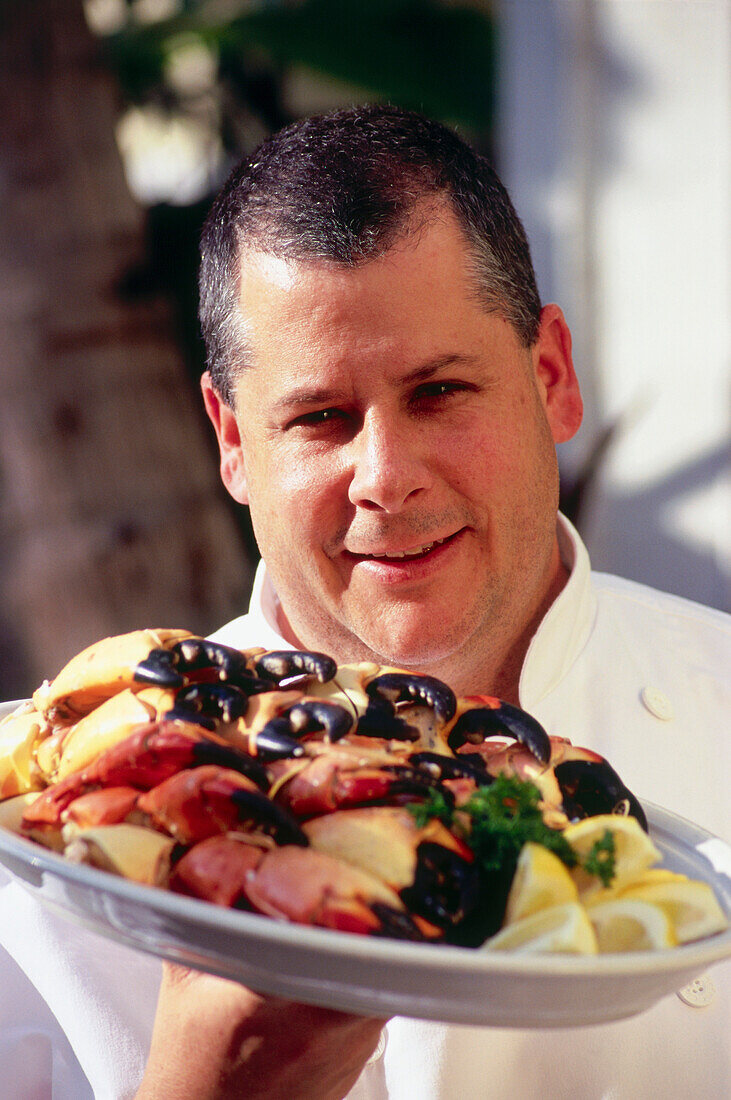 Koch mit Teller stone crabs, Restaurant Joe's Stone Crab, South Beach, Miami, Florida, USA