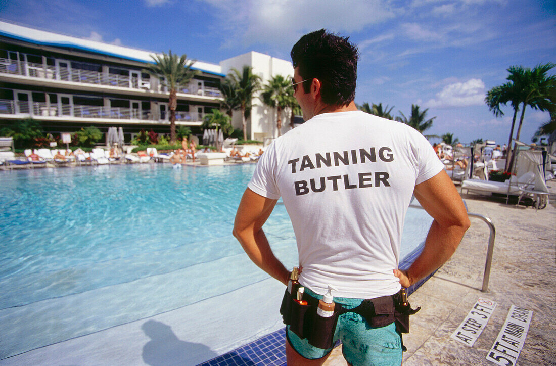 Junger Mann steht am Pool des Hotel Ritz Carlton in der Sonne, South Beach, Miami, Florida, USA