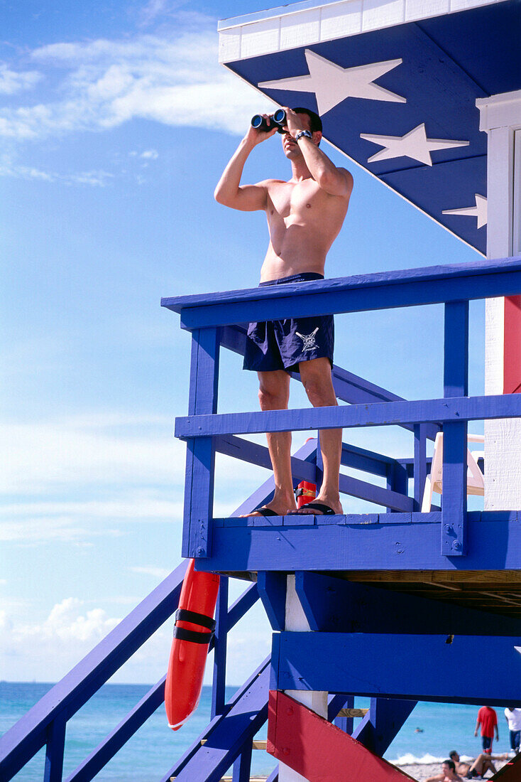 Rettungsschwimmer steht vor einem Rettungsschwimmerhäuschen am Strand, South Beach, Miami, Florida, USA