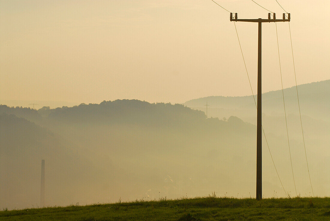 Pylon and morning haze at Hoerselberge, Thuringia, Germany