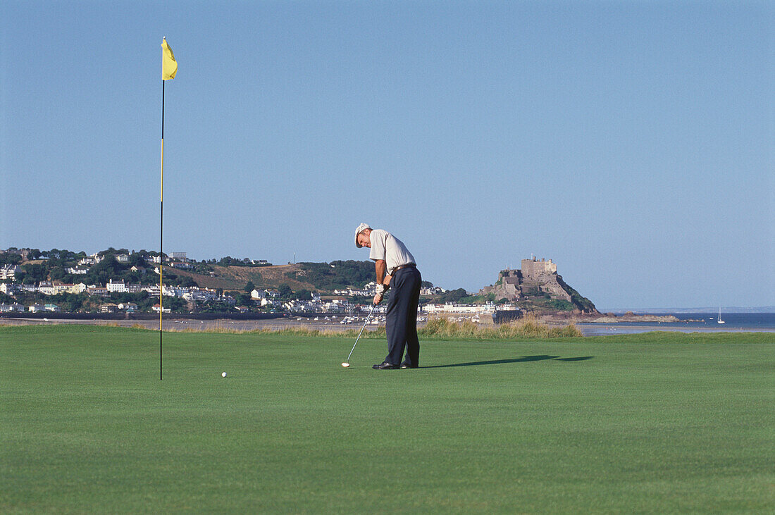Älterer Erwachsener, Mann spielt Golf, Golfplatz bei Gorey, Orgeuil Castle, Jersey, Kanalinseln, Großbritannien
