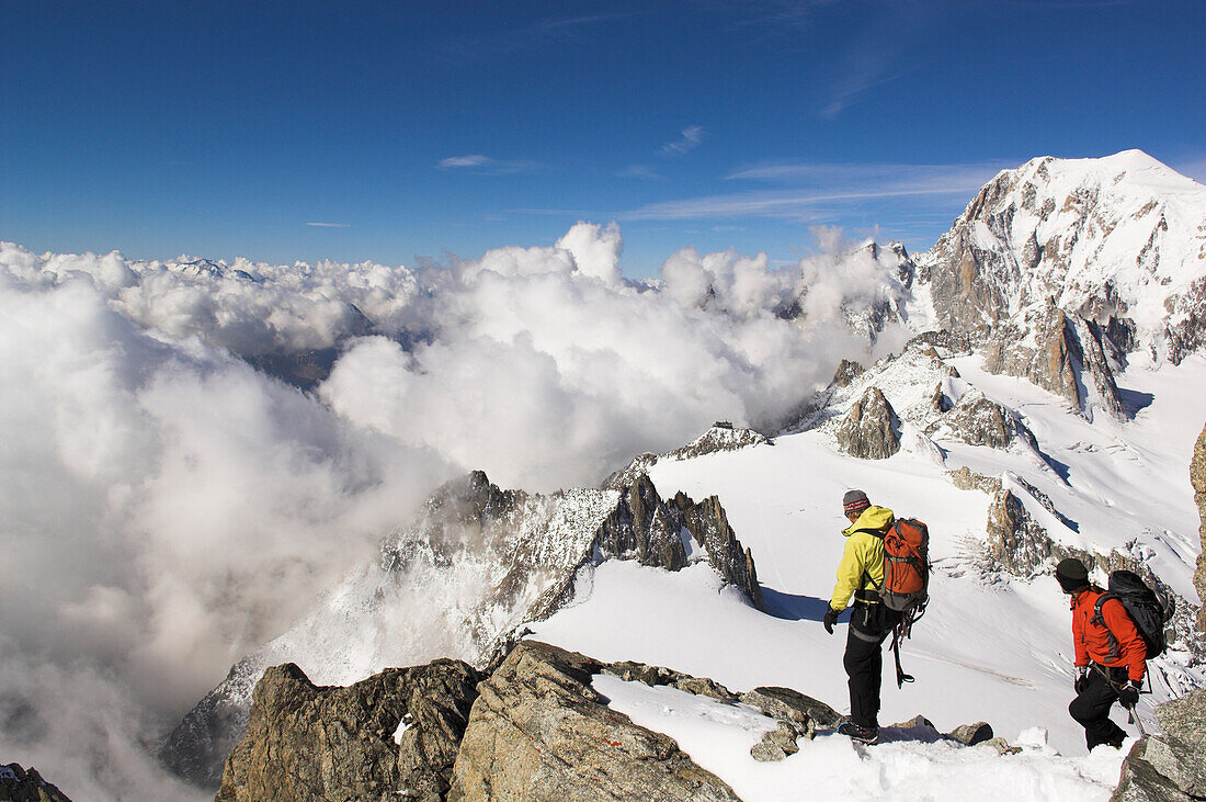 Zwei Bergsteiger besteigen Dent du Geant, Mont Blanc im Hintergrund, Frankreich, Italien