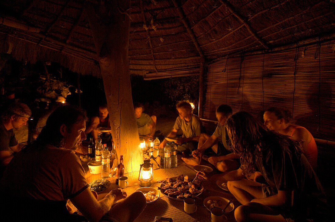 Eine Gruppe von Leute essen zur Abend in einer Hütte, Madagaskar, Afrika