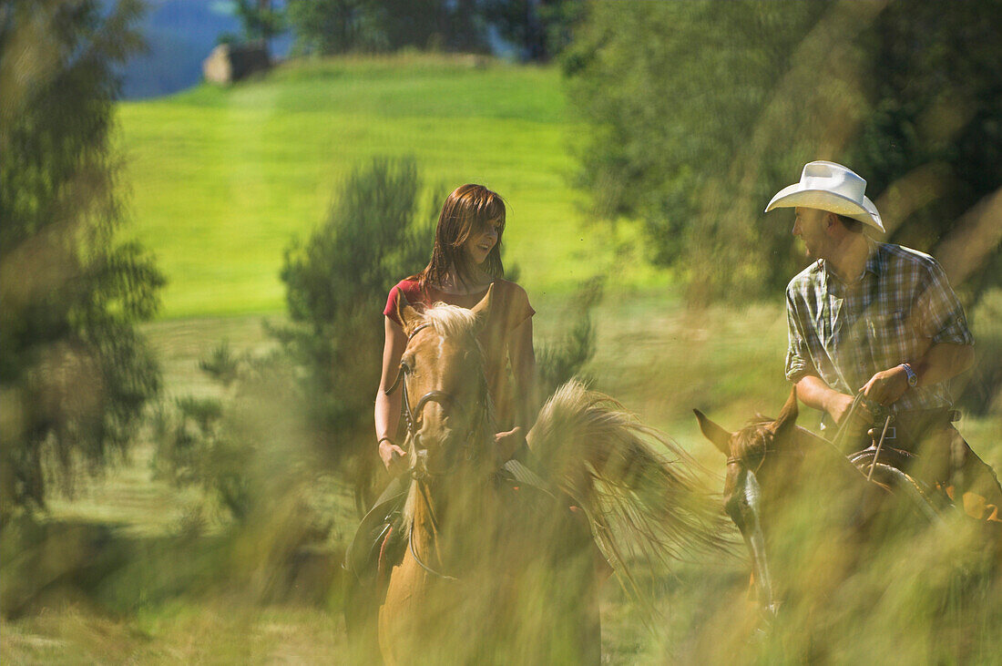 Two horseriders riding through a field, Muehlviertel, Upper Austria, Austria