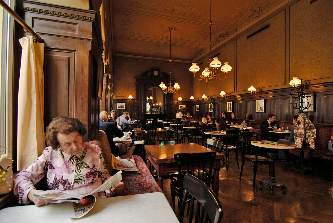 Ältere Frau liest Zeitung in Café Sperl, Wien, Österreich