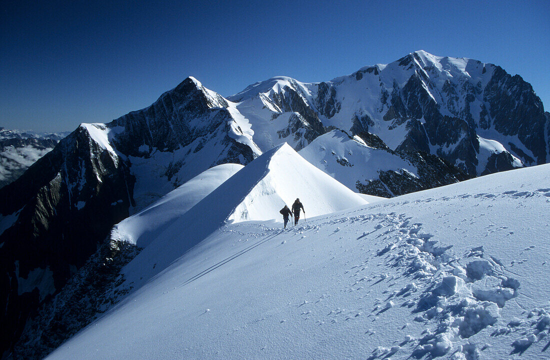 mountaineerers at ridge of Domes de Miage with Mont Blanc in background, Mont Blanc range, France