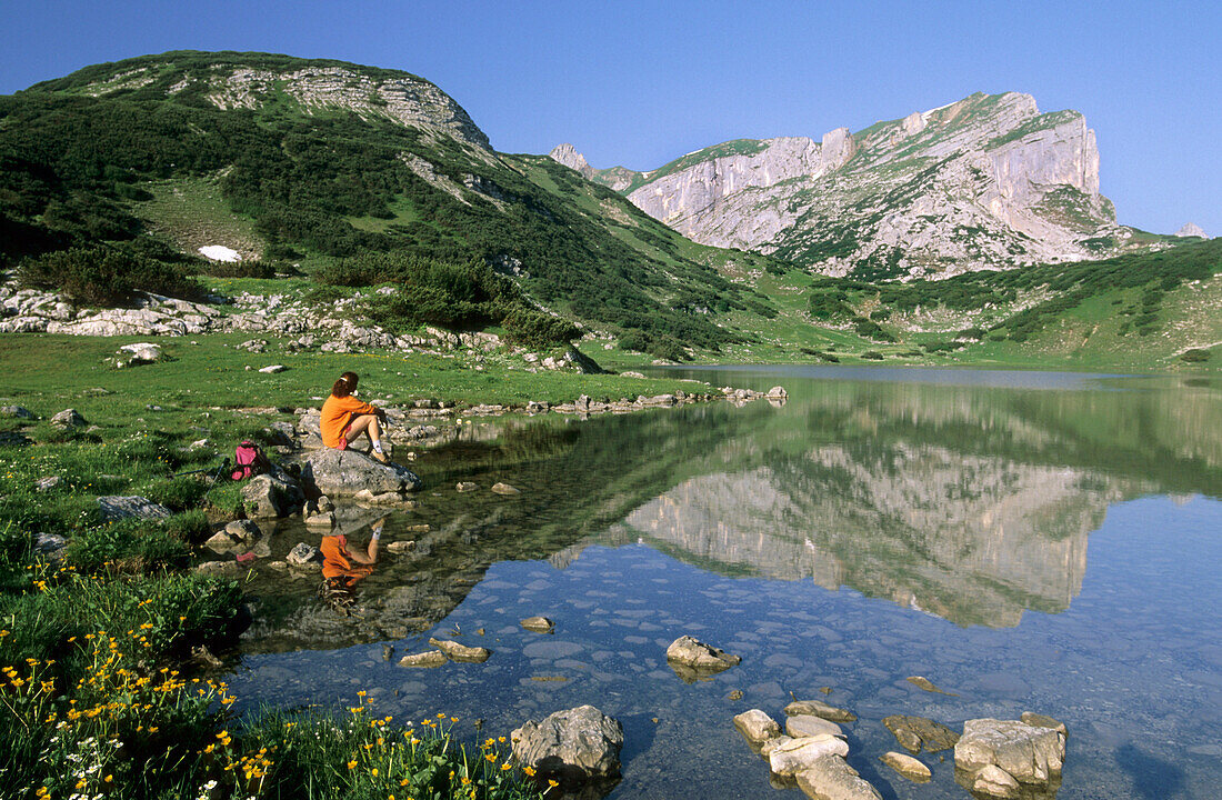 hiker resting at lake Ziereiner See, Roan range, Tyrol, Austria