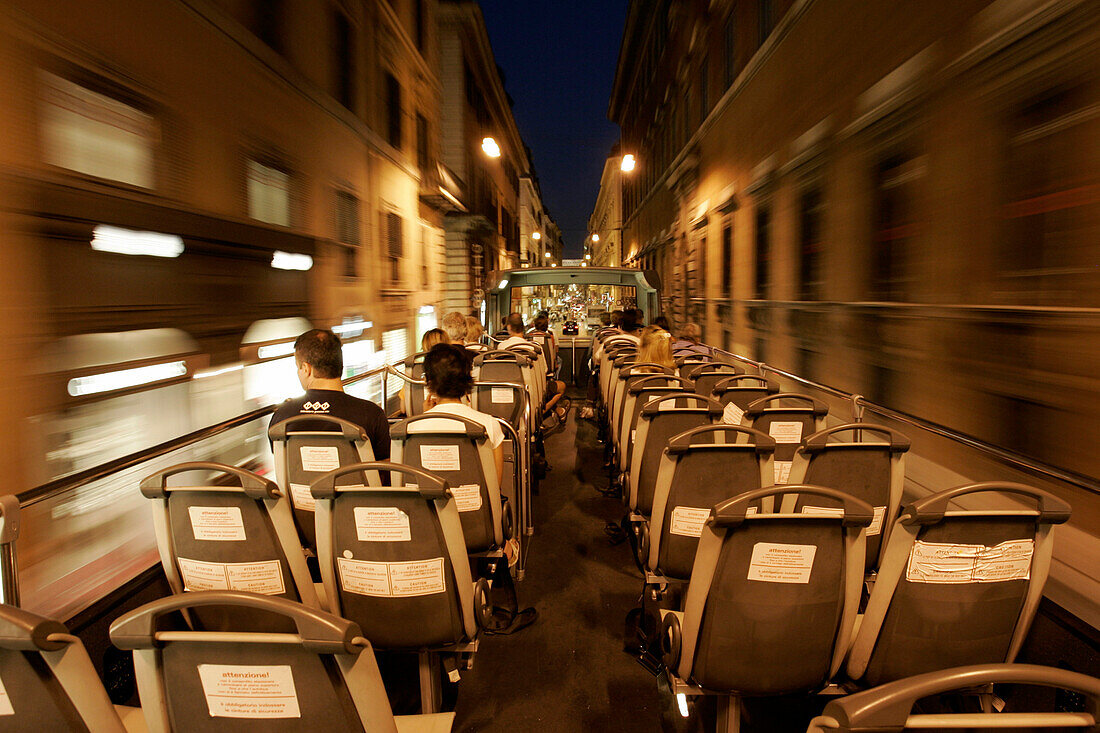 Touristen auf oberer Plattform des Besichtigungbusses bei Nacht, Rom, Italien