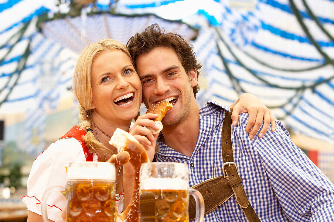 Paar mit Bier und Brezn im Bierzelt