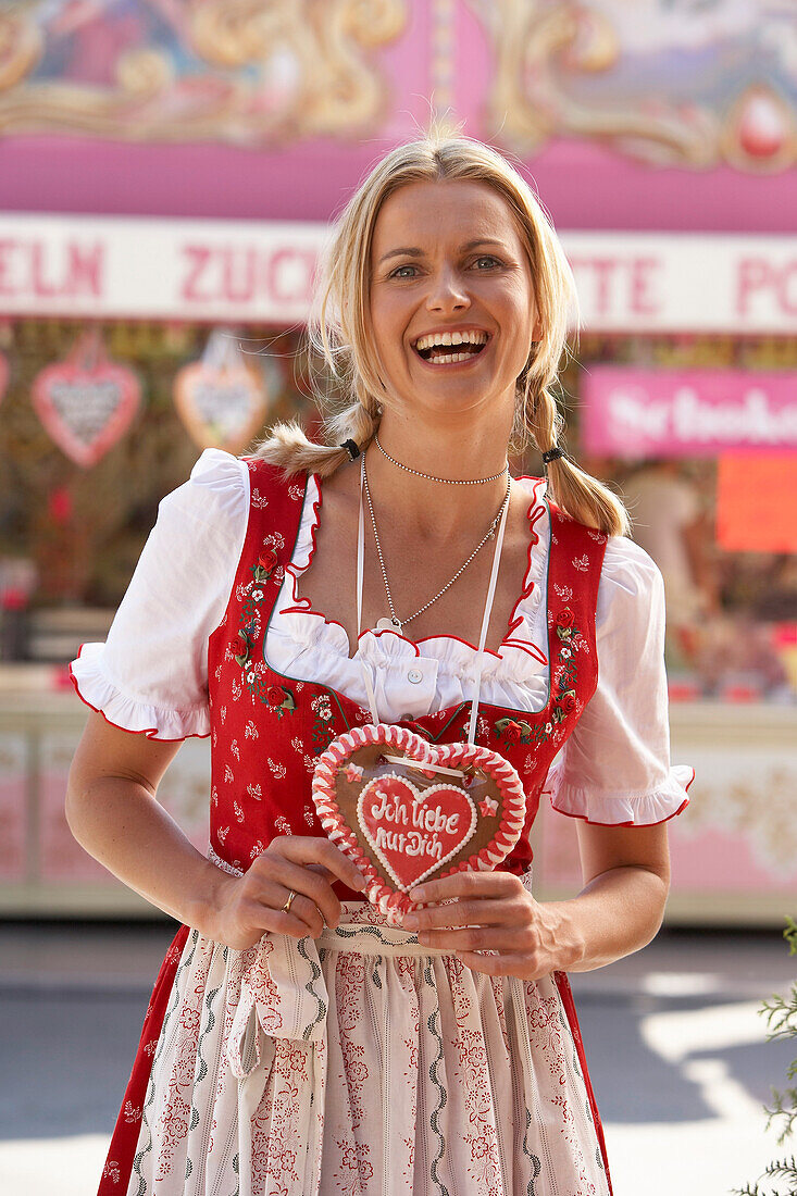 Mid adult woman wearing dirndl dress with a chocolate heart